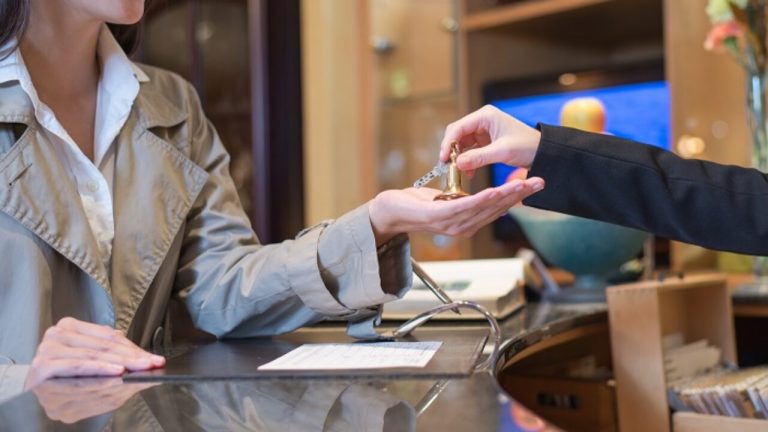 receptionist handing over keys to hotel room