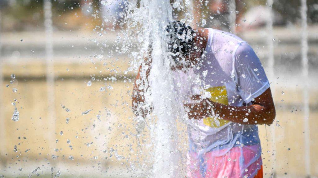 Caldo a Milano, turisti cercano refrigerio alla fontana di Piazza Castello