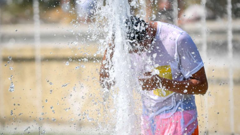 Caldo a Milano, turisti cercano refrigerio alla fontana di Piazza Castello