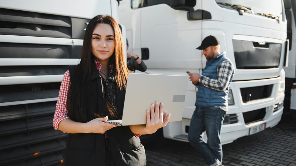 Young female truck driver using a laptop